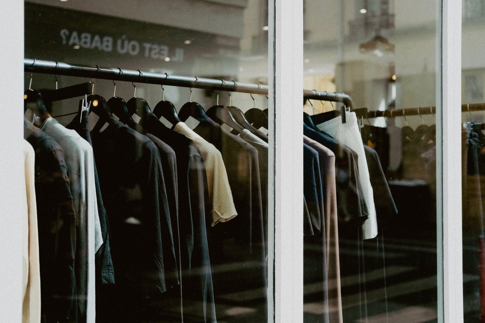 Jackets on a rail behind a shop window