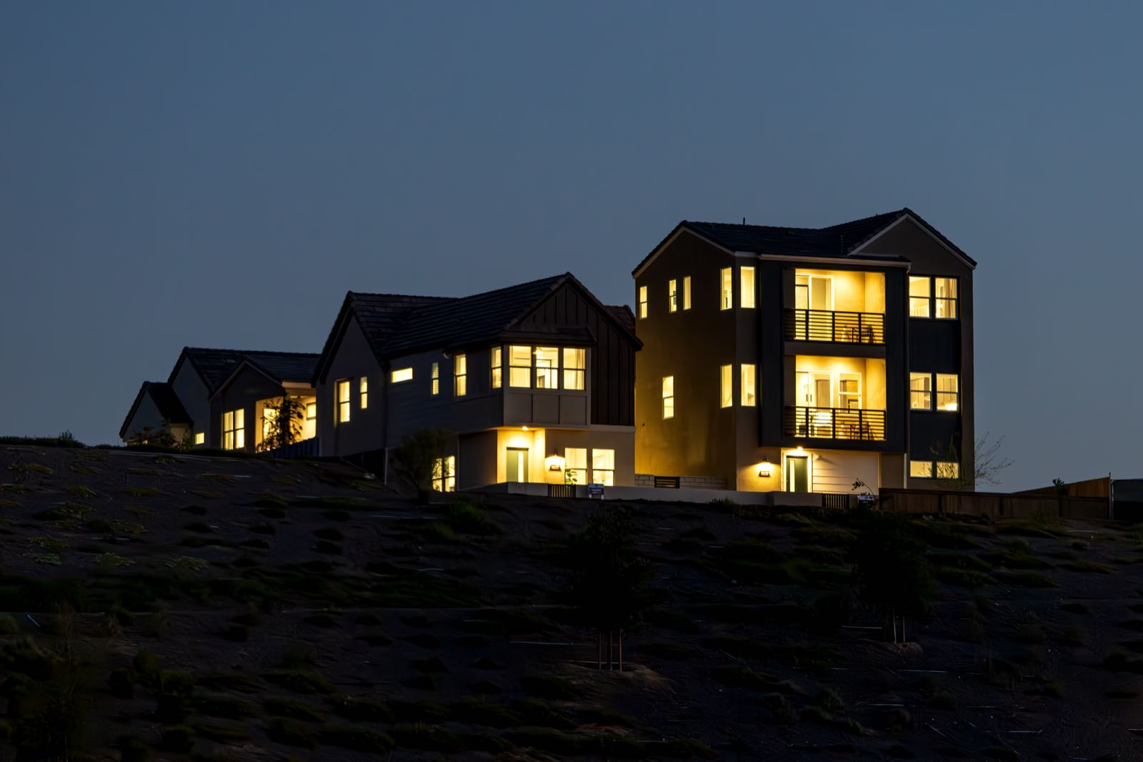 A modern house lit from inside at dusk