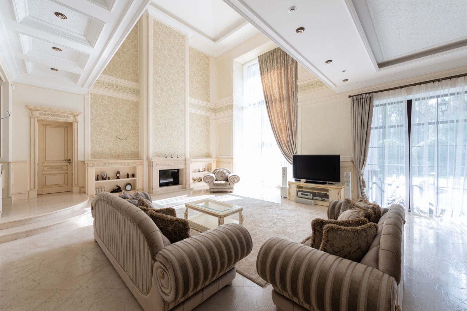A living room with striped armchairs and tall windows
