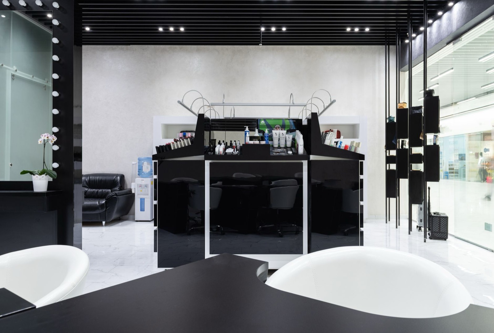 The studio: black basins and white chairs under a row of spotlights