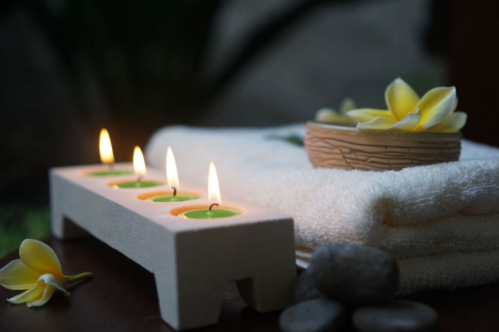 Candles, towels and a frangipani flower