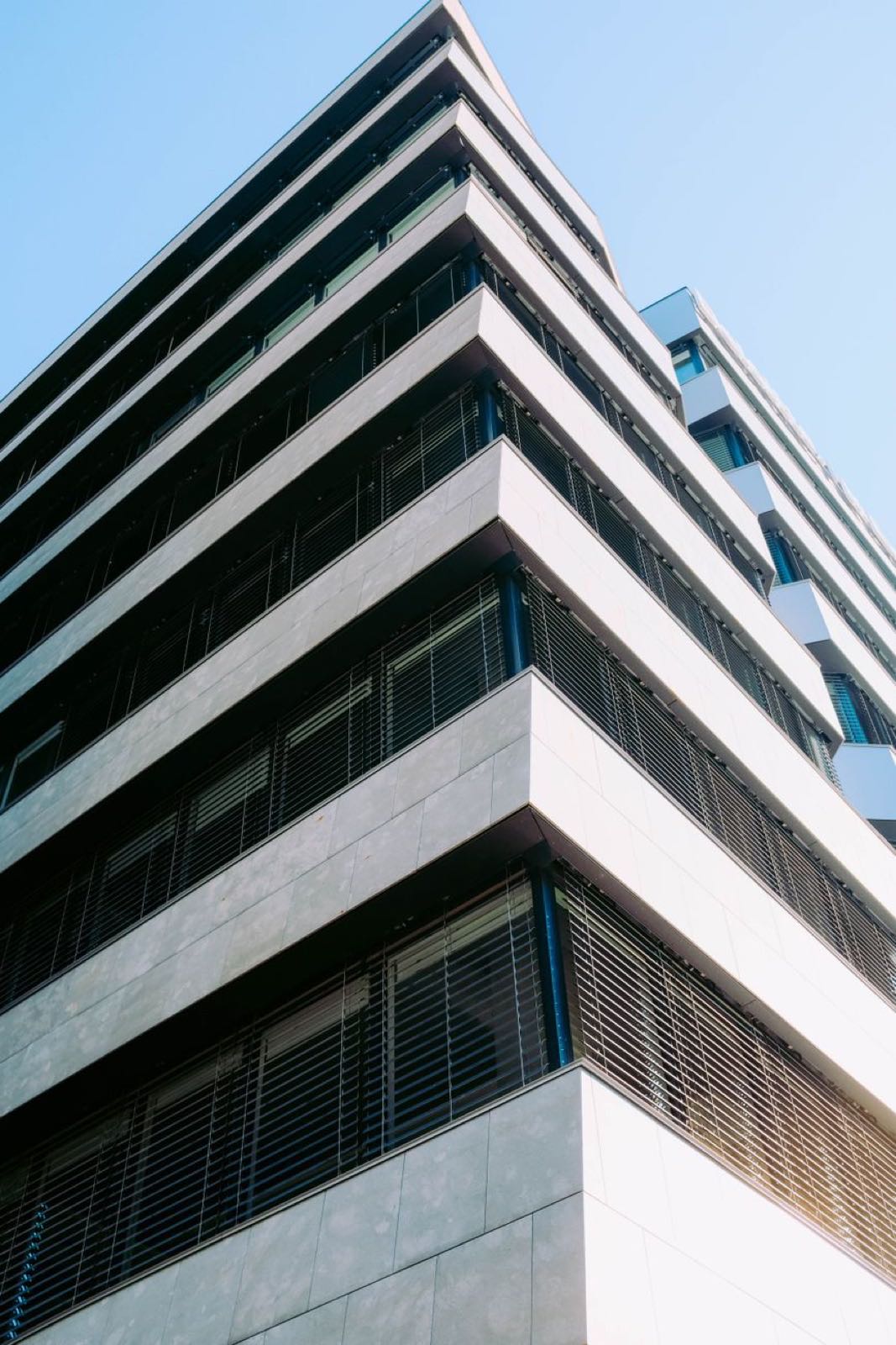 The corner of a white building with horizontal louvres