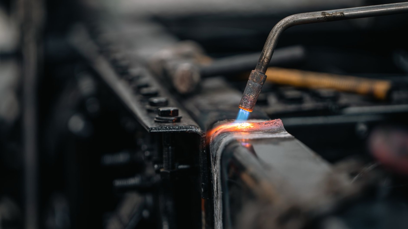 A blue flame on a burner rail, close up