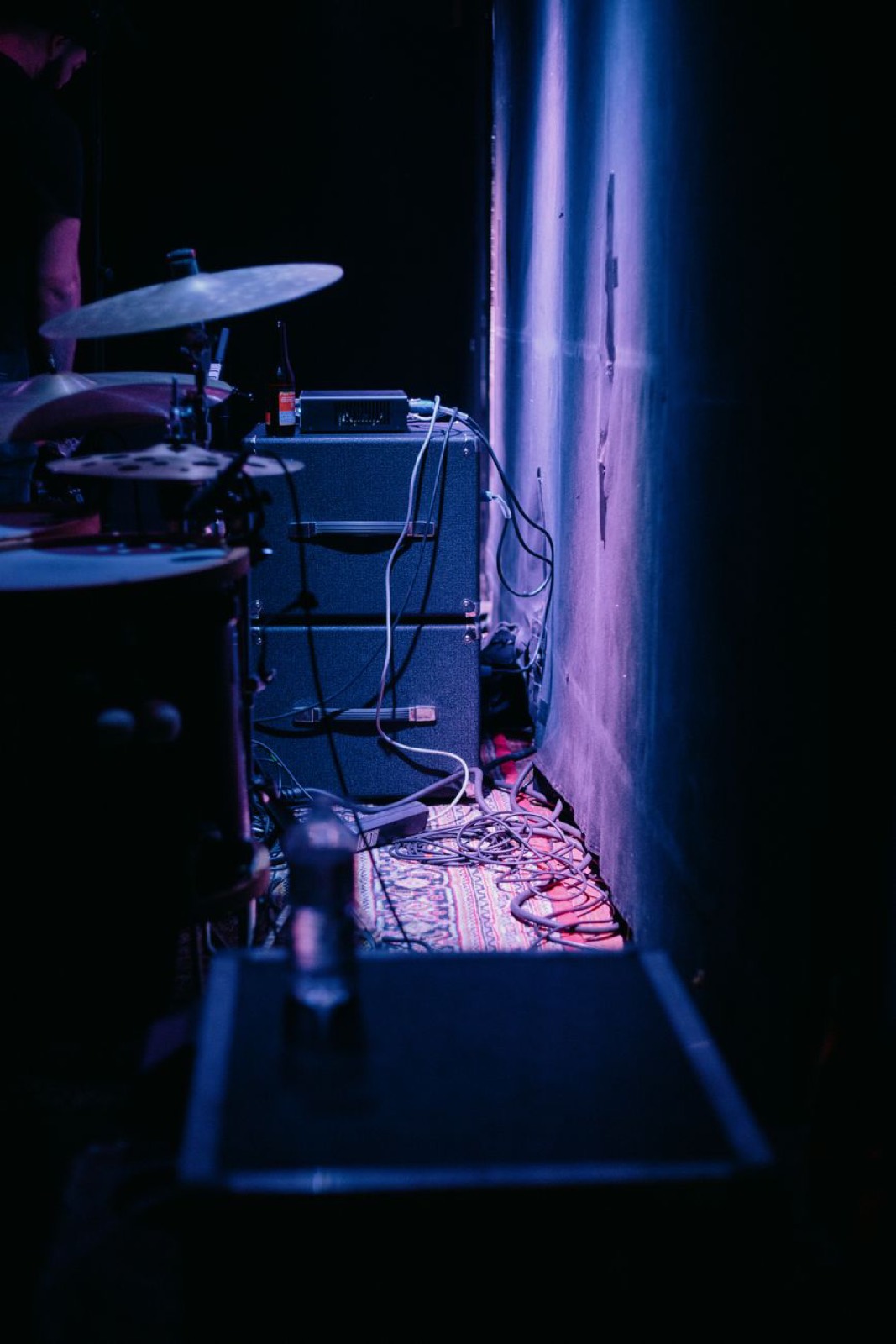 Amps and cables backstage in violet light