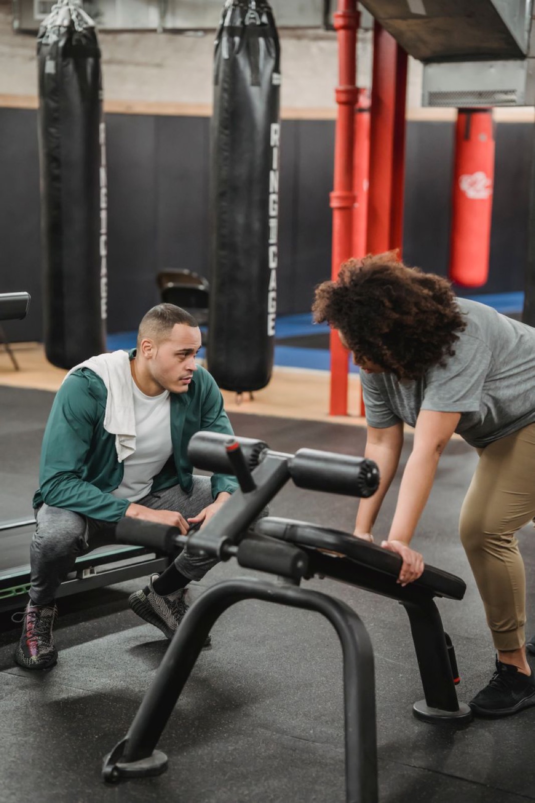 A coach guiding a member through a bench press, week thirty